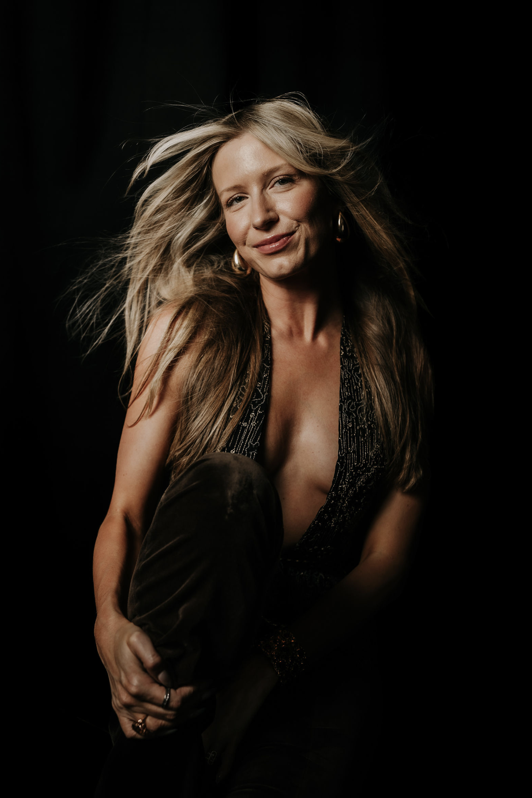 Brittany seated in a dark beaded halter top